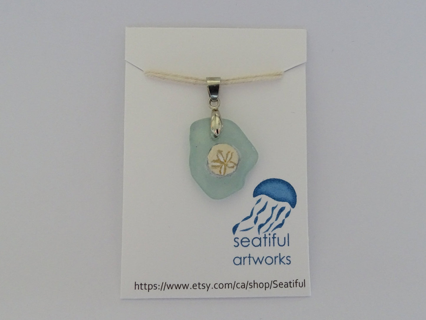 Sand dollar painted on green sea glass pendant