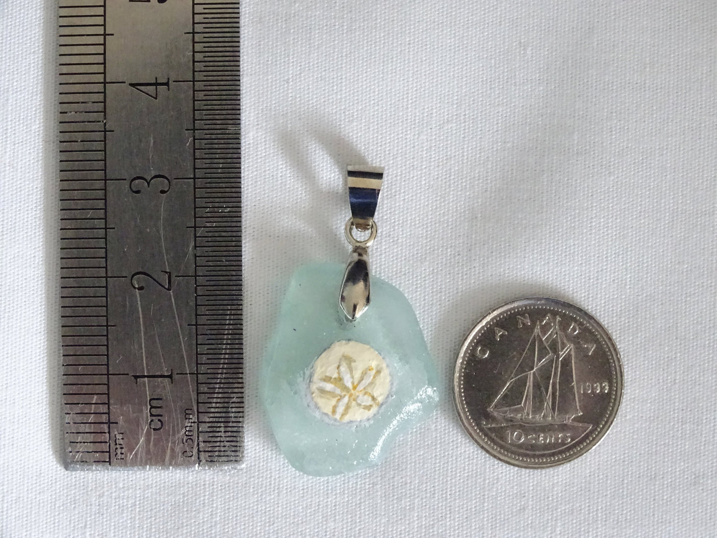 Sand dollar painted on green sea glass pendant